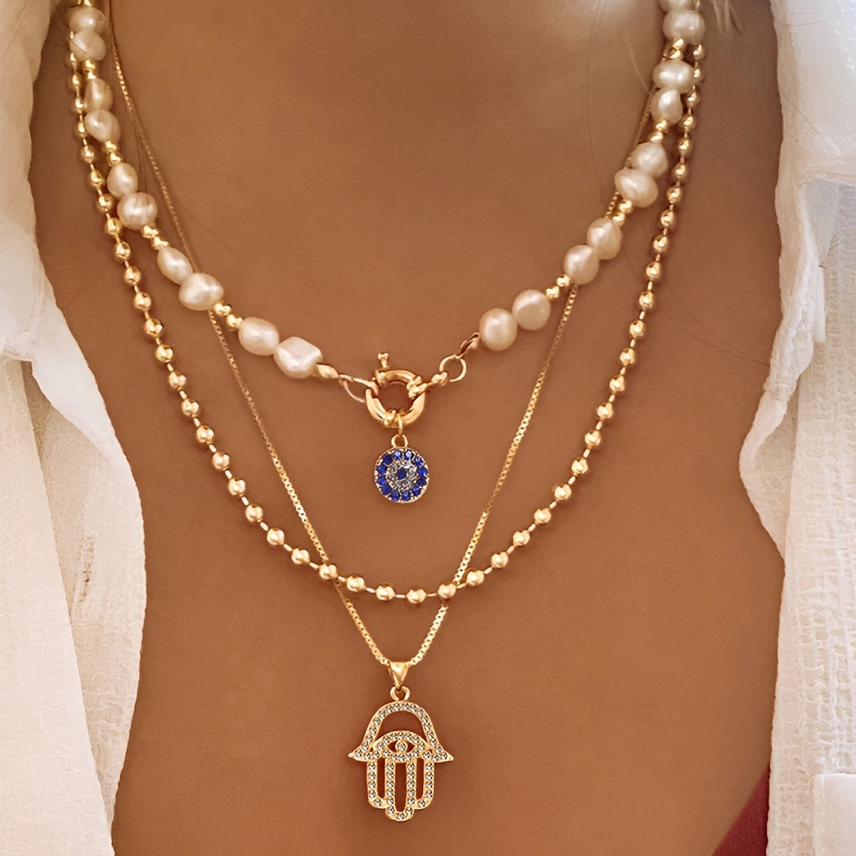 Nadia – Necklace with multiple rows of pearls and Hamsa hand