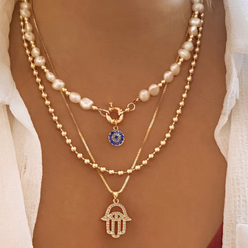 Nadia – Necklace with multiple rows of pearls and Hamsa hand