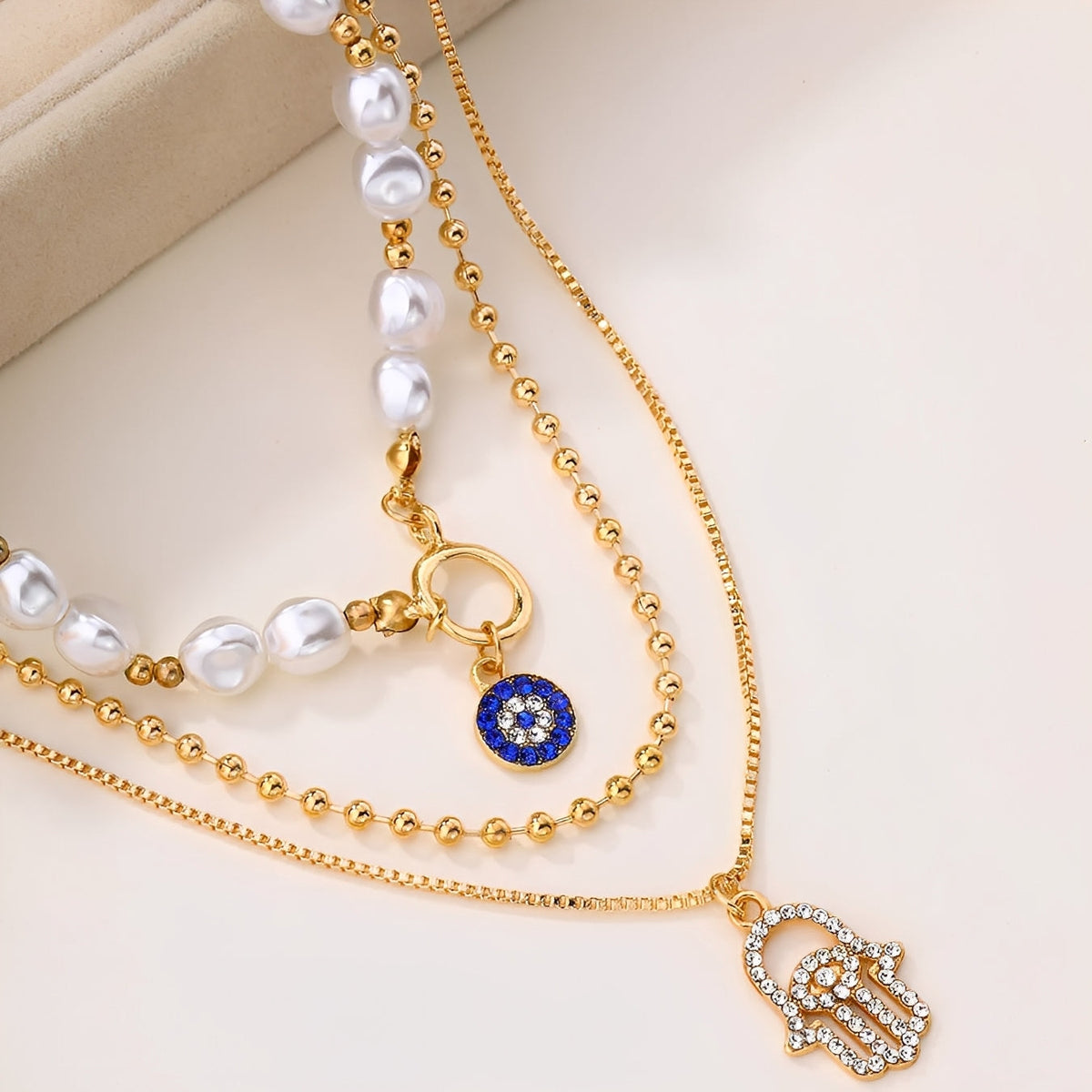 Nadia – Necklace with multiple rows of pearls and Hamsa hand